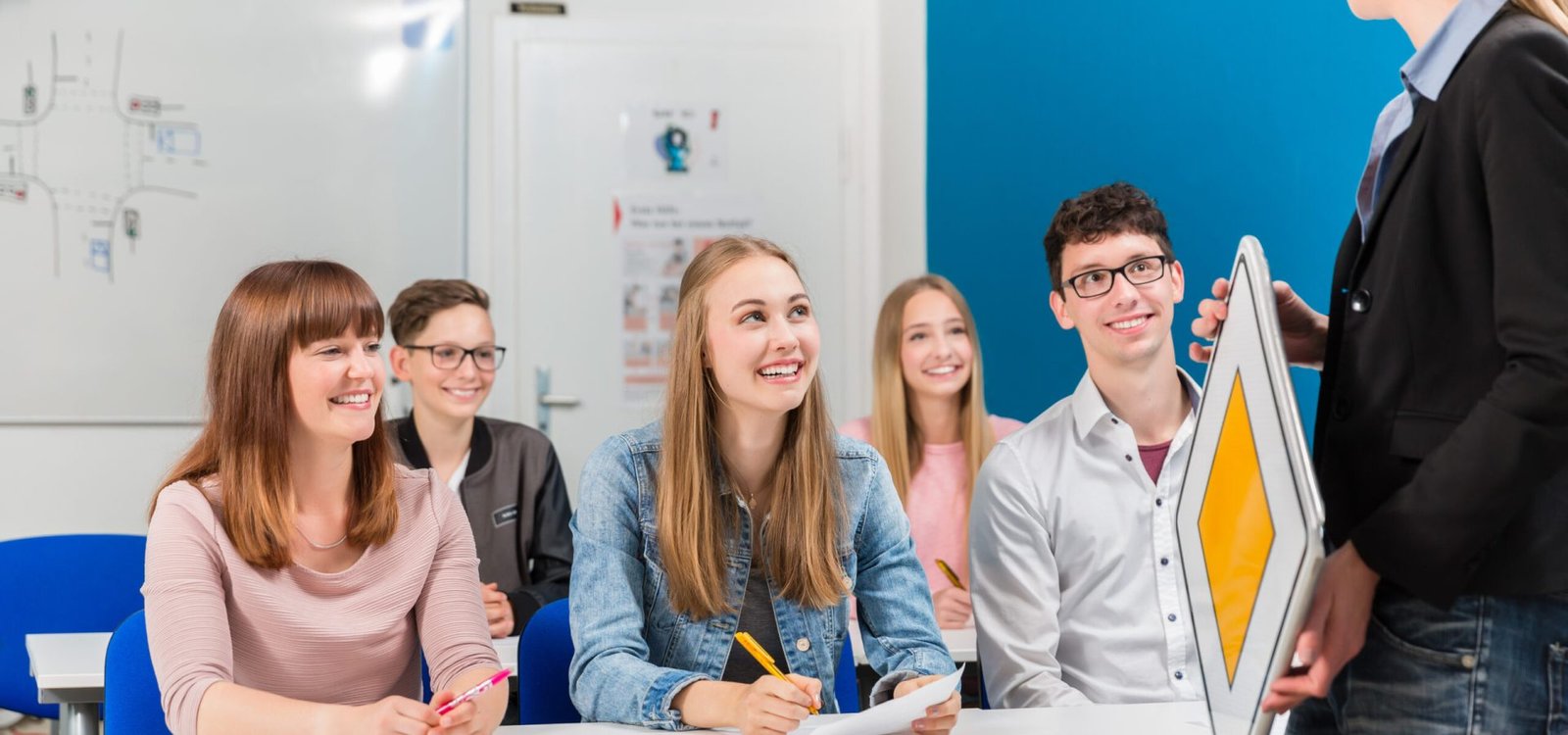 Students listing to their teacher in driving class learning