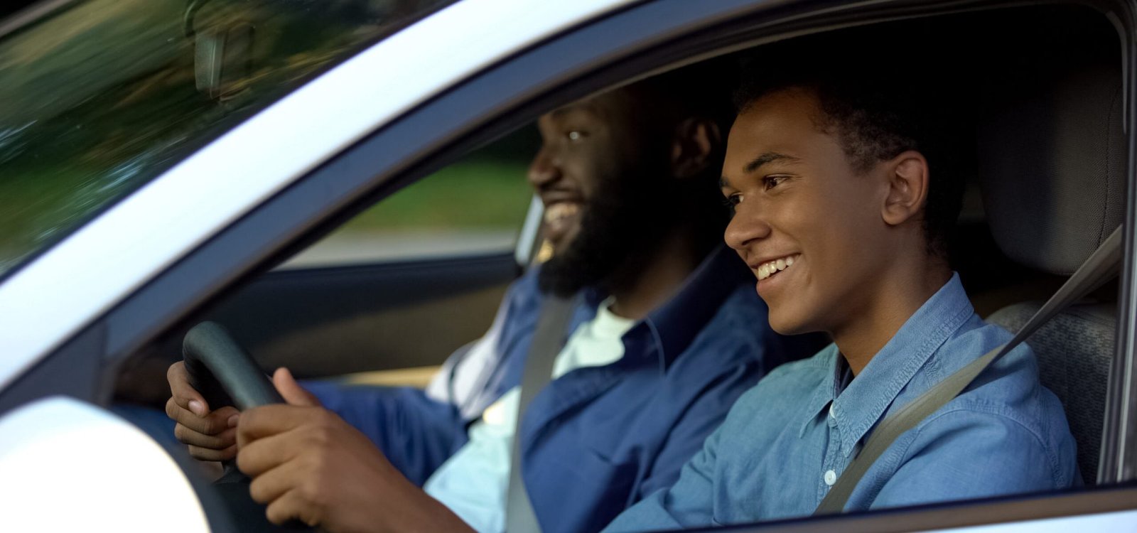 Male examiner pleased with young male passing driving test, support and help